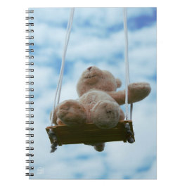 Beertje op schommel met bewolkte blauwe lucht. notitieboek