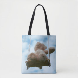 Beertje op schommel met bewolkte blauwe lucht. tote bag