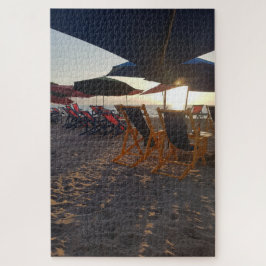 Beschaduwde strandzitplaatsen bij zonsondergang legpuzzel