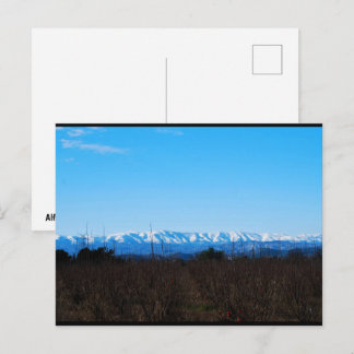Besneeuwde bergen achter kaki veld briefkaart