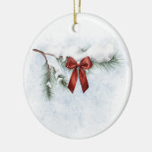 besneeuwde dennentak met een feestelijke rode stri keramisch ornament (Links)