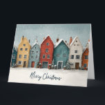 Betoverend Besneeuwd Dorp "Prettig Kerstfeest" Kaart<br><div class="desc">Een hartverwarmende en artistieke illustratie in watercolorstijl van een rij kleurrijke, Noordse huizen tijdens een zachte wintersneeuwval. De huizen, geschilderd in tinten mosterdgeel, diep rood, turquoise en zachtgrijs, hebben sneeuwbedekte daken en gloeiende ramen. Kleine ingepotte groenblijvende planten en feestelijke decoraties omzomen de straat voor de gebouwen. De elegante, handgeschreven tekst...</div>