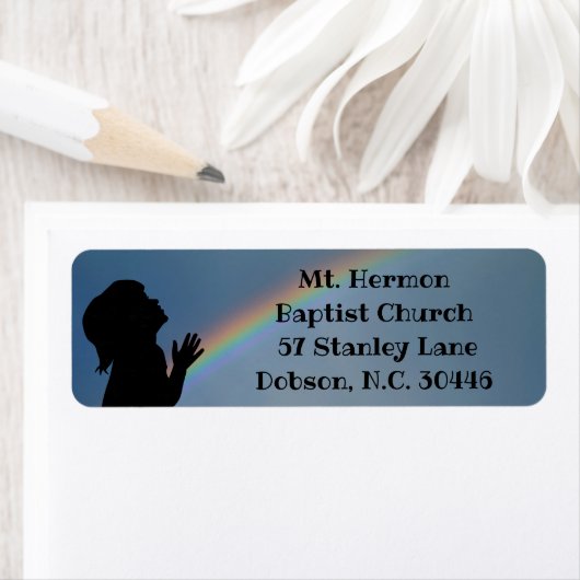 BIDDEND KIND MET REGENBOOG ETIKET (Insitu)