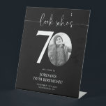 Black 70th Birthday Welcome Sign | Kijk eens wie 7 Reclamebord Met Voetstuk<br><div class="desc">Welkom gasten op uw 70e verjaardag viering met deze prachtige bewerkbare welkomstbord. Met een strakke, aanpasbare lay-out kunt u met deze sjabloon eenvoudig uw eigen foto toevoegen en de tekst personaliseren, waardoor het een perfecte aanvulling is op uw mijlpaal 70e verjaardagsdecor. Ideaal voor ingangen of als een feest brandpunt, dit...</div>