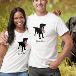 Black Lab Dog met Amerikaanse vlag, 4 juli T-shirt<br><div class="desc">Een zwarte labrador rekende hond silhouette houdt een Amerikaanse vlag in zijn mond klaar voor de vierde juli of een andere patriottische viering. Voeg je eigen tekst toe - "Happy 4th of Juli" of de naam of schrapping van je hond. Dit maakt een schattig, feestelijk ontwerp voor een vierde van...</div>