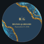 Blauw- en goudgetijden Glitter Wedding Ronde Sticker<br><div class="desc">Een prachtig blauw en goudgeo-agate kristallijne vormgeving met gouden glitteraccenten. Dit elegante, elegante vormgeving met blauwachtige tinten en gouden creëer is een gesofisticeerd, amethiekst stuk abstracte kunst. De combinatie van de blauwe en gouden kleuren creëer een gesofisticeerde, trendy en chic stijl. Elegant trouwsticker ontwerp met moderne elementen. De eenvoudige opstelling...</div>