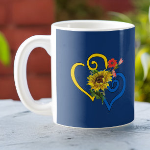 Blauw geel verdraaid hart met zonnebloem op de mar koffiemok