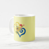 Blauw geel verdraaid hart met zonnebloem op geel mok (Voorkant links)