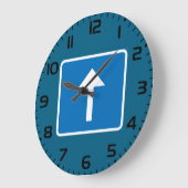 Blauw verkeersbord voor eenrichtingsverkeer met pi grote klok (Hoek)