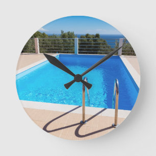 Blauw zwembad met treden op het zee ronde klok