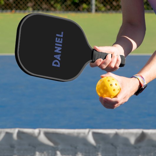 Blauwe aangepaste naam op zwart pickleball paddle (Insitu)