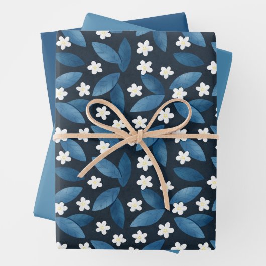 Blauwe bladeren en witte bloemen op donkere achter inpakpapier vel (In situ)