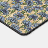 Blauwe cornbloemen, wilde bloemen op honnegeel bureaumat (Hoek)