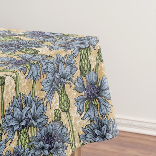 Blauwe cornbloemen, wilde bloemen op honnegeel tafelkleed (Voorbeeld)