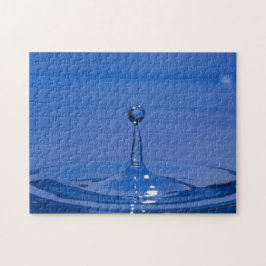Blauwe druppel water in beweging op een puzzel