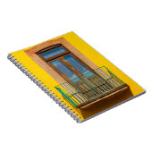Blauwe houten deur op een geel betongebouw notitieboek (Rechterzijde)