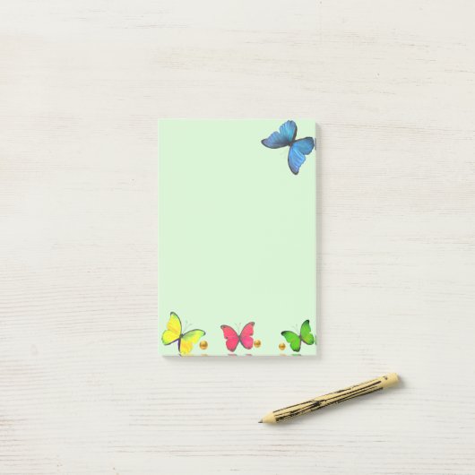 Blauwe rode en gele vlinders op lichtgroen post-it® notes (Op bureau)