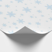 Blauwe sneeuwvlokken in het wit cadeaupapier (Hoek)