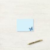 Blauwe vlinder en gouden Confetti op lichtblauw Post-it® Notes (Op bureau)