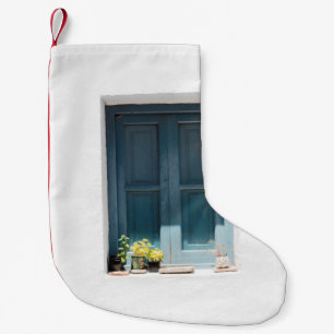 BLAUWE WOODEN DEUR OP WITTE CONCRETE WAL KLEINE KERSTSOK