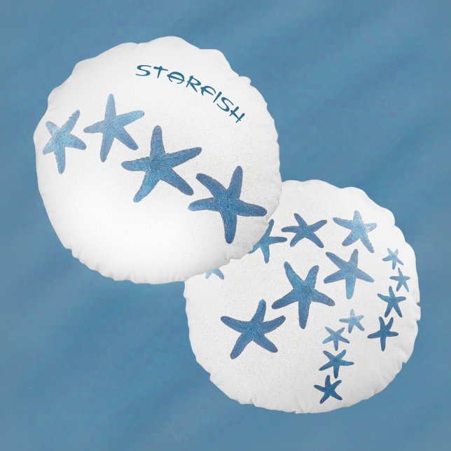 Blauwe zeester op wit zand rond kussen (Creator heeft geüpload)