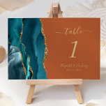 Blauwgroen gouden agaat verbrande Sinaasappel brui Kaart<br><div class="desc">De linkerkant van deze elegante moderne bruidstafelnummerkaart is voorzien van een blauwgroen blauw waterverf agaatrand afgesneden met faux gouden glitter. De aanpasbare tekst combineert goudkleurig handschrift,  cursief en koperplaat lettertypen op een gebrande oranje achtergrond.</div>