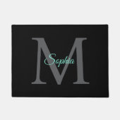 Blauwgroen scriptnaam, groot grijs monogram op zwa deurmat (Voorkant)