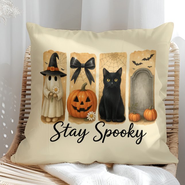 Blijf Spooky Halloween Brush Stroke Cat Kussen ("Stay Spooky" Halloween Brush Stroke Cat Throw Pillow on a sunny boho rattan chair.)