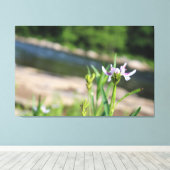 Bloem ondersteund door River Canvas Print (Insitu (Houten vloer))
