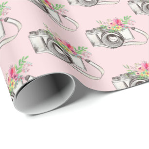 Bloemen en camera op roze cadeaupapier