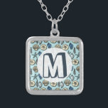 Blue Shell Starfish Zee Pattern Monogram Zilver Vergulden Ketting<br><div class="desc">Voeg uw eigen monogram/initiaal toe aan dit , blauwe en roomzegel en zeemijlvormig patroon. Het bedekt afbeeldingen van het strand en de zomer. Er zijn vijf soorten schelpen in het ontwerp en één zeester. Ideaal voor de stijl van zeeschepen, stranden, oceanen, kustthema's en decor. De lichtblauwe achtergrondkleur kan worden aangepast...</div>