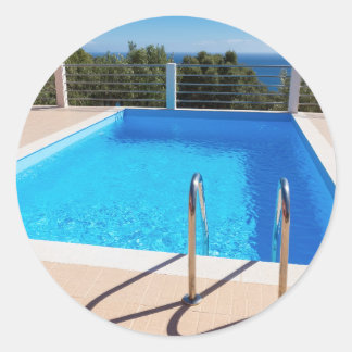 Blue swimming pool with steps at sea ronde sticker