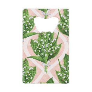 Boeket van lelie van de vallei bloemen op roze creditkaart flessenopener