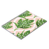 Boeket van lelie van de vallei bloemen op roze notitieboek (Linkerzijde)