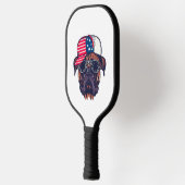 Bokser hond draagt wit rood blauw pickleball paddle (Links)