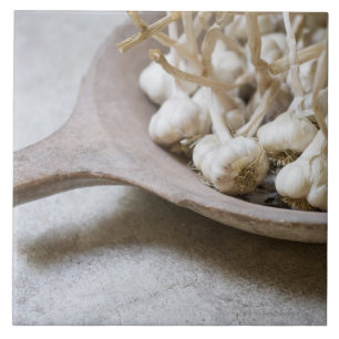 Bollen knoflook in een schaal met aardewerk tegeltje
