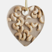 Bovenste uitzicht op ruwe cashewnoten, verspreid o keramisch ornament (Rechts)