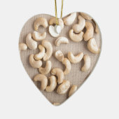 Bovenste uitzicht op ruwe cashewnoten, verspreid o keramisch ornament (Links)