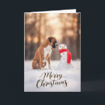 Boxer Dog Christmas Snowman Feestdagen Kaart<br><div class="desc">A heartwarming winter holiday scene featuring a Boxer dog sitting in fresh snow beside a cheerful little snowman wrapped in a bright red scarf. Soft golden winter light and gently falling snow create a peaceful seasonal moment that highlights the playful personality and loyal spirit Boxers are known for. Perfect for...</div>