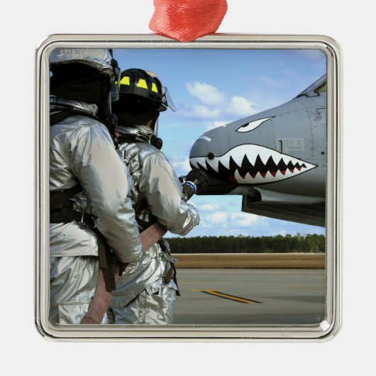 Brandweerlieden plaatsen een brandslang tijdens ee metalen ornament (Voorkant)