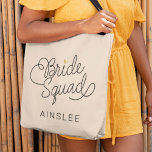 Bride Squad Modern Script Gold Wedding Name Tote Bag<br><div class="desc">Deze moderne canvas tas met een minimalistisch ontwerp voor casual scriptscriptkalligrafie, waarin BRIDE SQUAD wordt gelezen, en de aangepaste naam van uw eermeisje of bruidsmeisje bevat schone lijnen om een gestroomlijnde en gesofisticeerde vormgeving te creëer. De ondergewaardeerde stijl met de kleine goudkleurige gouden hartdetails voegt een beetje verfijning toe aan...</div>