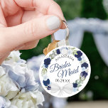 Bridesmaid Blue Waterverf Floral Wreath Wedding Sleutelhanger<br><div class="desc">Deze sleutelhangers zijn ontworpen om bruidsmeisjes in je bruiloft te bevoordelen. Ze zijn voorzien van een bijtende hand geschilderd waterverf met een breed scala aan rozen en bloemen in tinten van stoffige blauw, marine en indigoeroe. De tekst wordt geschreven in elegante manuscriptbrieven, en er is ruimte voor haar naam en...</div>