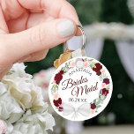 Bridesmaid Elegant Red Floral Wreath Weddenschap Sleutelhanger<br><div class="desc">Deze sleutelhangers zijn ontworpen om bruidsmeisjes in je bruiloft te bevoordelen. Ze zijn voorzien van een roesterig handbeschilderd waterverf ontwerp met een breed scala aan rozen en bloemen in tinten van rood, onbeschoft en wazig roze. De tekst wordt geschreven in elegante manuscriptbrieven, en er is ruimte voor haar naam en...</div>