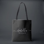 Bruidsmeisje Gift Gepersonaliseerd Zwart Tote Bag<br><div class="desc">Deze bruidsmeisje accessoiretas is voorzien van een handgeschreven witte script typografie met moerassen op een zwarte achtergrond. Cadeau uw bruidsmeisjes met een canvas tas voor kleine items die traditioneel worden gepresenteerd tijdens het repetitiediner,  voor gebruik in de vroege morgen voor de bruiloft.</div>