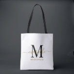 Bruidsmeisje Gift Goud Zwart Monogram Wit Tote Bag<br><div class="desc">Deze bruidsmeisje canvas tas is voorzien van een handgeschreven gouden en zwarte script typografie monogram met moerassen op een witte achtergrond. Cadeau uw bruidsmeisjes met een tas voor het dragen van items op de dag van de bruiloft,  en traditioneel gepresenteerd tijdens het repetitiediner of daarvoor.</div>
