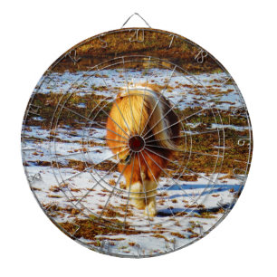 Bruin en roomminiatuur paard in de sneeuw. dartbord