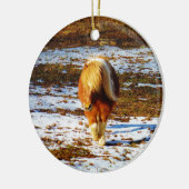 Bruin en roomminiatuur paard in de sneeuw. keramisch ornament (Links)