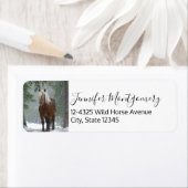 Bruin paard in een winterbos met sneeuwval etiket (Insitu)