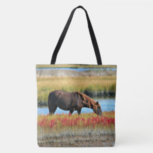 Bruine paard dat graast op een waterweide tote bag