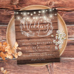 Budget Rustic Wood String Light Wedding Invitation<br><div class="desc">Met  snaarlampen en een handgetekende bloemenslinger kan deze elegante budget rustieke houten bruiloft uitnodiging worden gepersonaliseerd met uw informatie in chique belettering op een houten panelen achtergrond. Ontworpen door Thisnotme©</div>